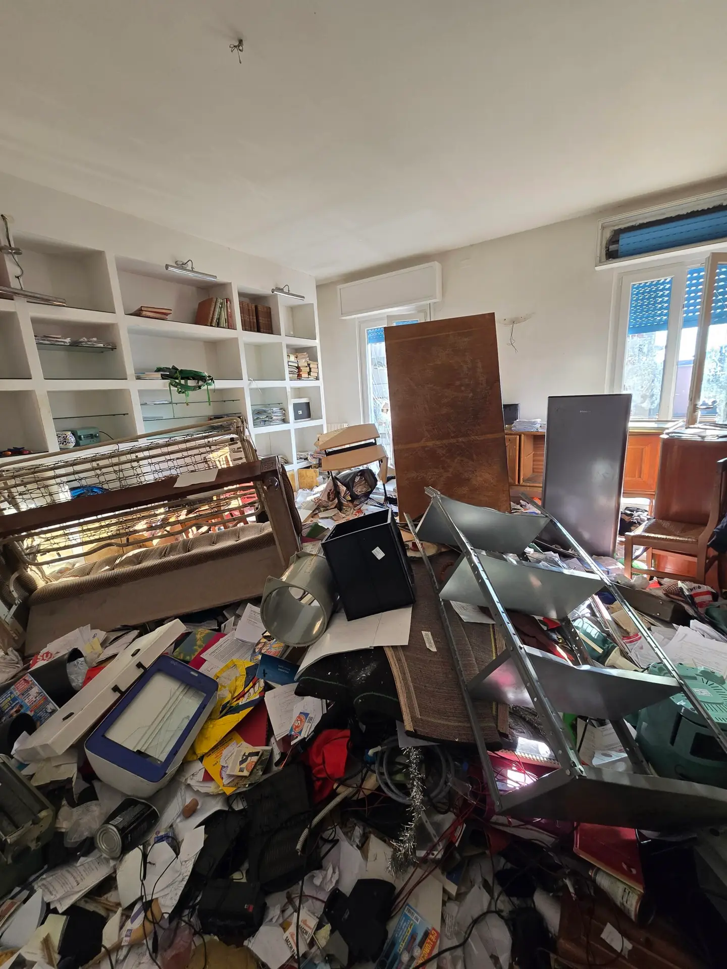 Soggiorno pieno di mobili e oggetti prima dello sgombero a Golosine Verona