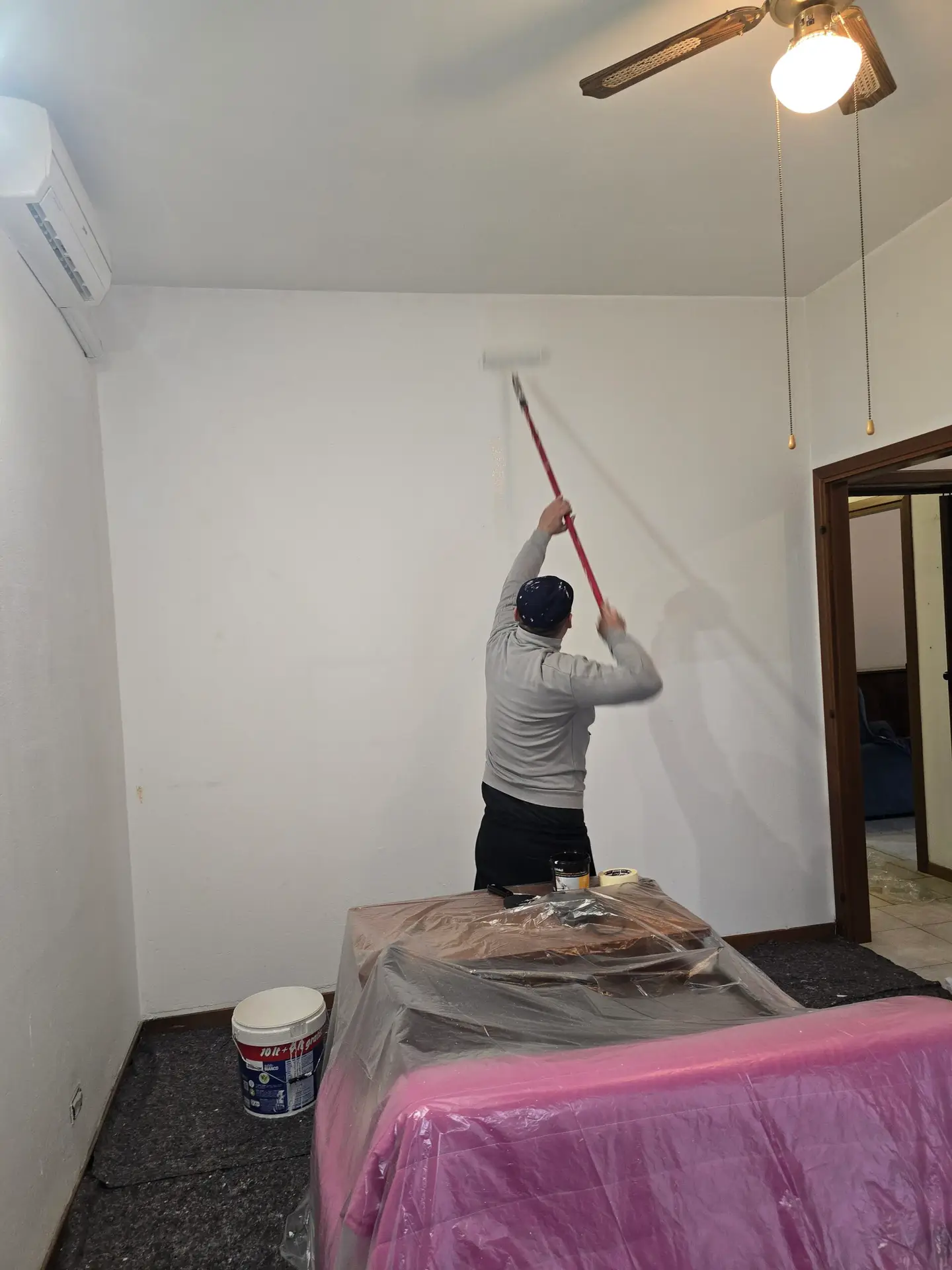 Imbianchino al lavoro durante pitture interne a San Michele Extra Verona