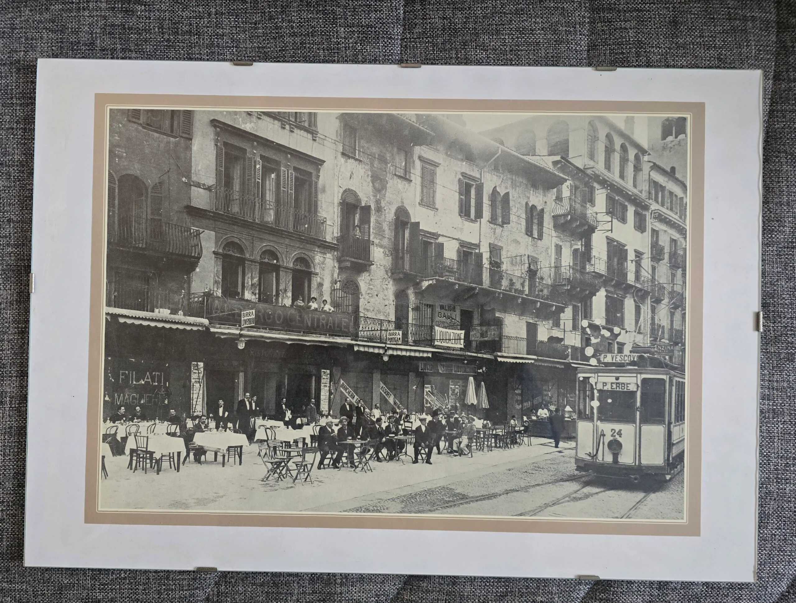 Fotografia storica di Verona con tram e tavolini all’aperto