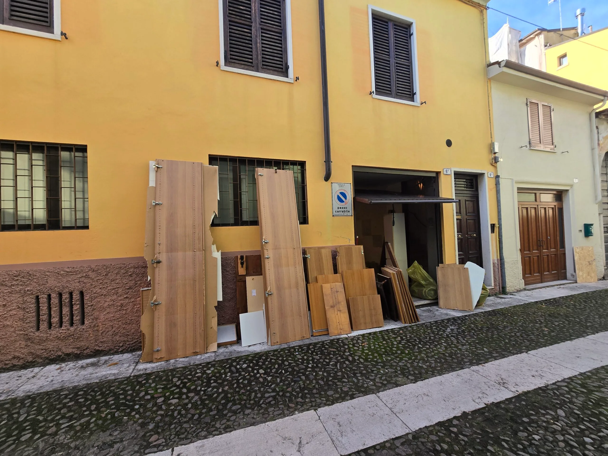 Porte e pannelli appoggiati all’esterno del garage durante le fasi di sgombero in Vicolo Cieco Porta Palio